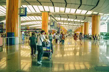 Traveler smiles at camera in busy airport